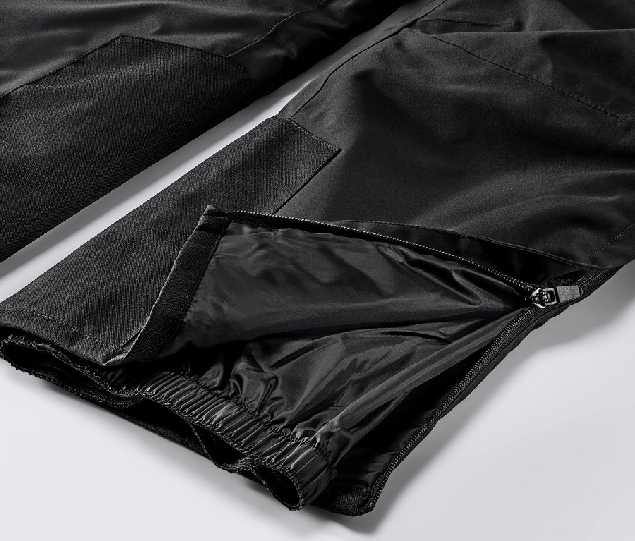 Zbliżenie na czarne, profesjonalne spodnie narciarskie z zamkiem błyskawicznym na nogawce.