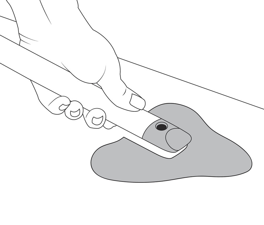 Ręka trzyma szczotkę do fug 4 w 1 i czyści szary brud.