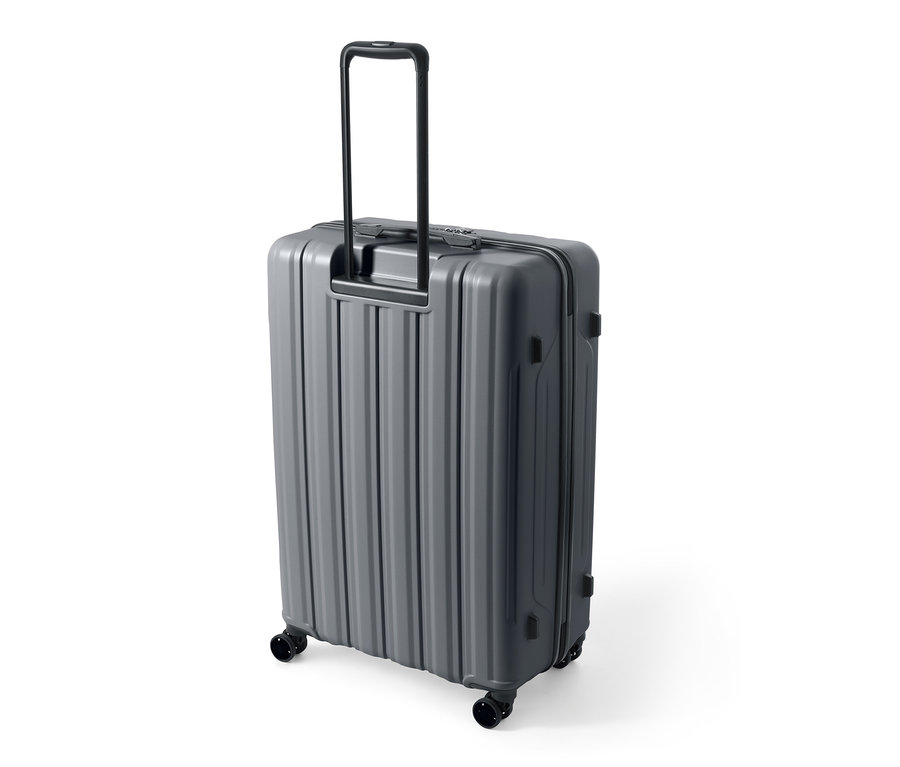 Szara, duża walizka z twardą skorupą wykonana z materiału pochodzącego z recyklingu z wysuniętą rączką.