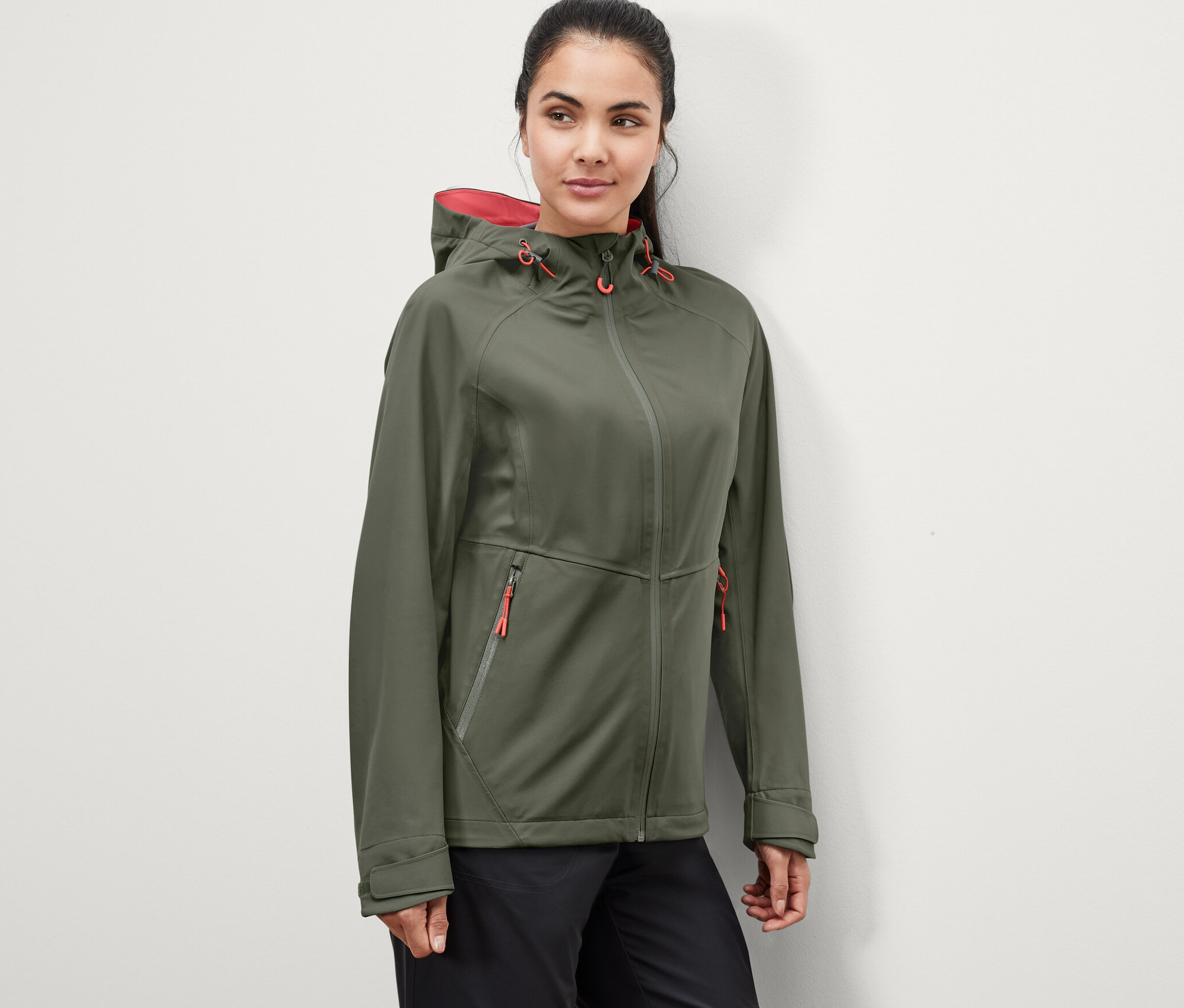 Kobieta ma na sobie zieloną, 3-warstwową kurtkę funkcyjną.