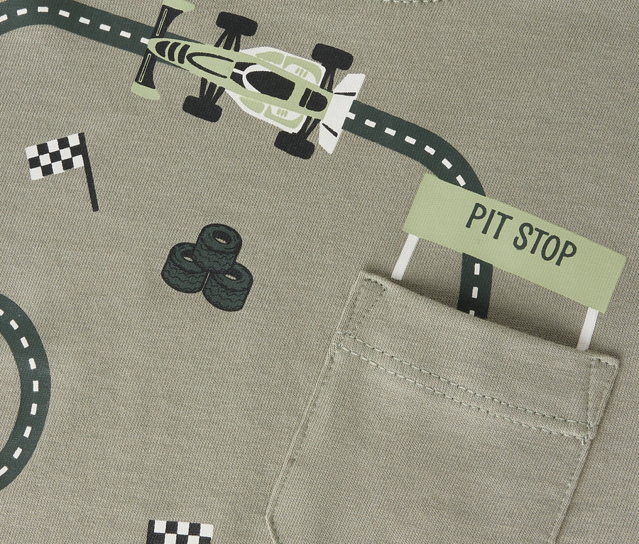 Nadruk na oliwkowej koszulce Name it z torem wyścigowym, bolidem, stosem opon i flagami.