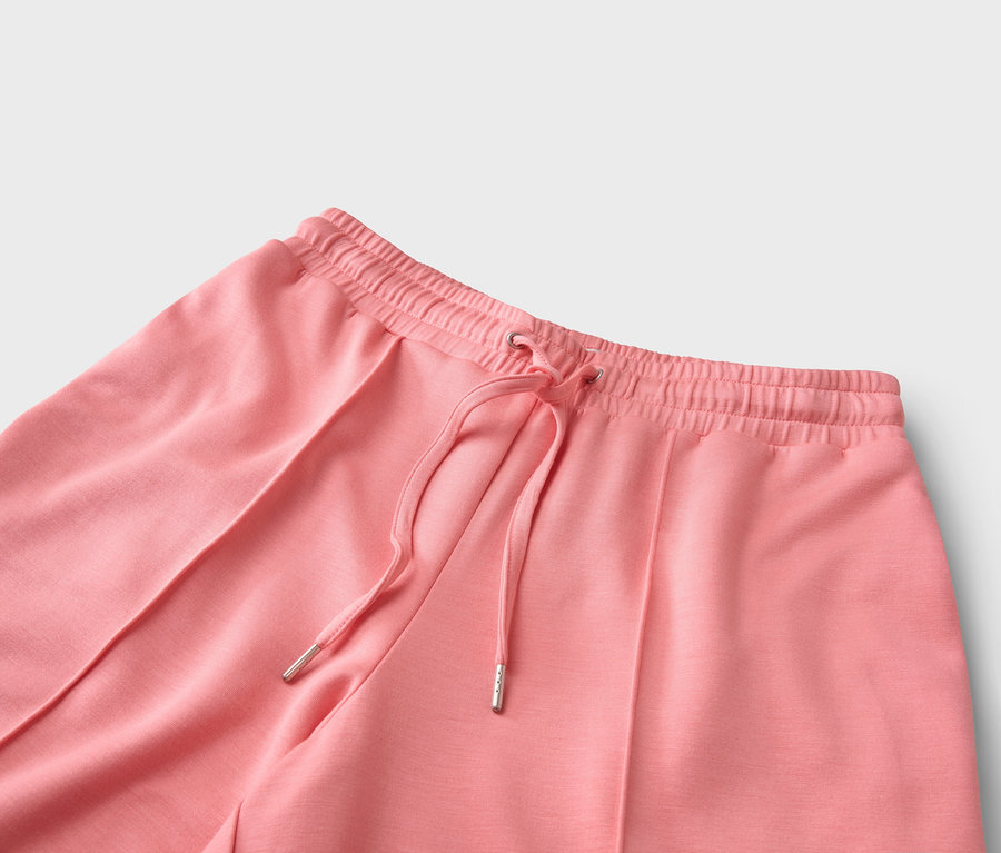 Zbliżenie koralowych spodni ze sznurkiem.