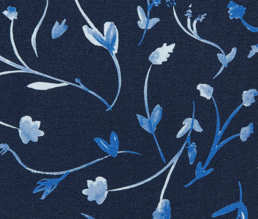 Zbliżenie na granatowe spodnie dżersejowe z nadrukiem na całej powierzchni.