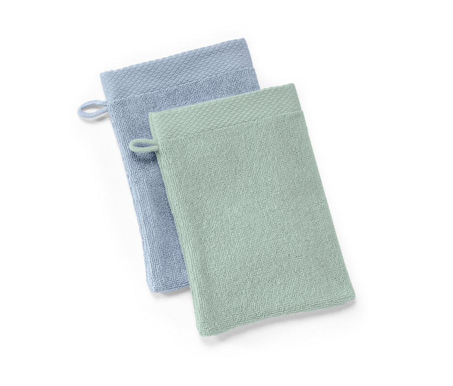 Dwie myjki do kąpieli: jasnoniebieska i jasnozielona.