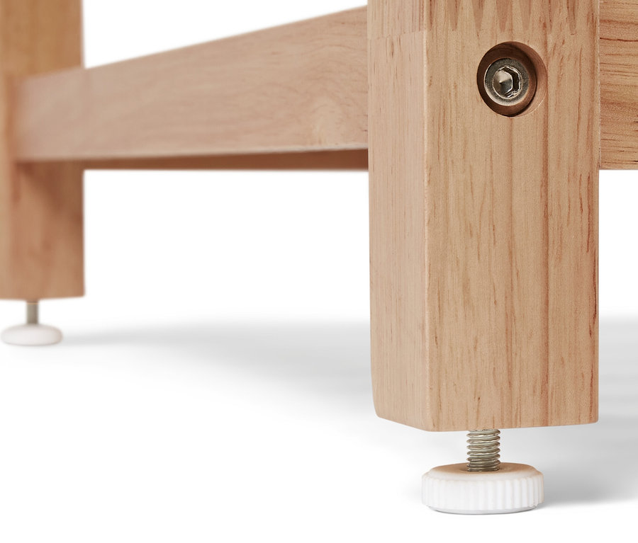 Fragment rogu regału z litego drewna z regulowaną nóżką.