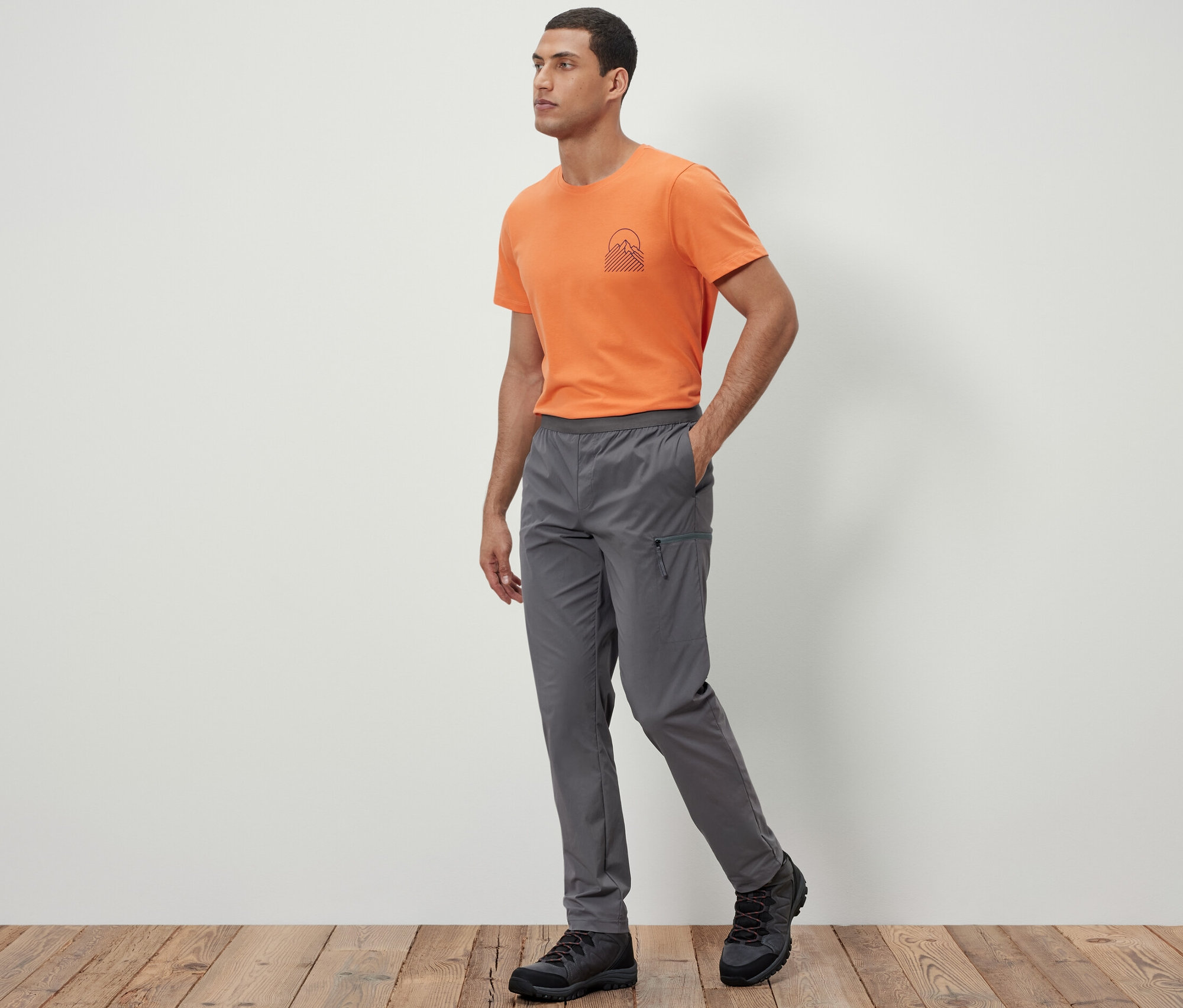 Mężczyzna idzie i ma na sobie lekkie spodnie funkcyjne.