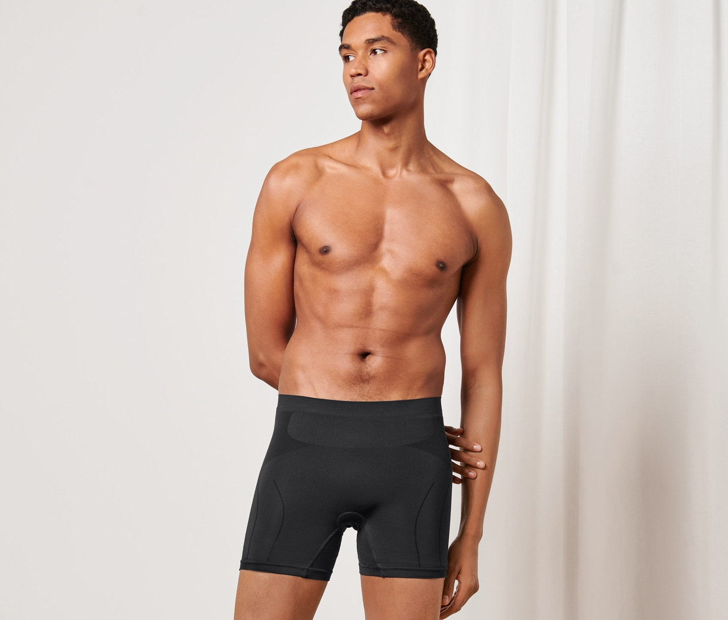 Mężczyzna pozuje w czarnych bokserkach na rower.