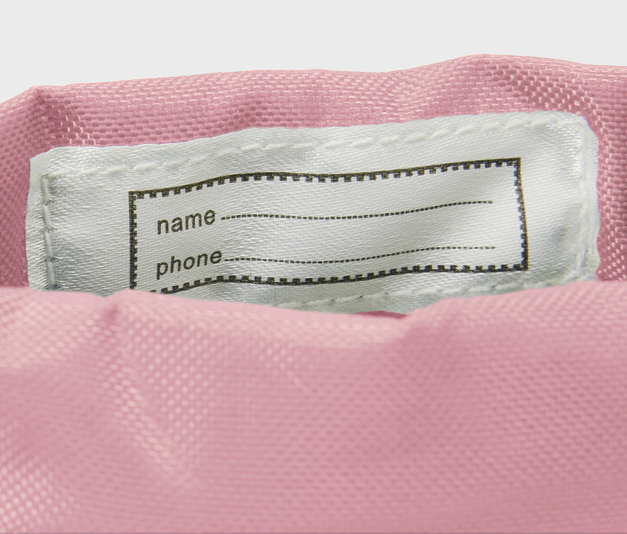 Zbliżenie na kalosze we wzór w kwiatki z etykietą na imię.