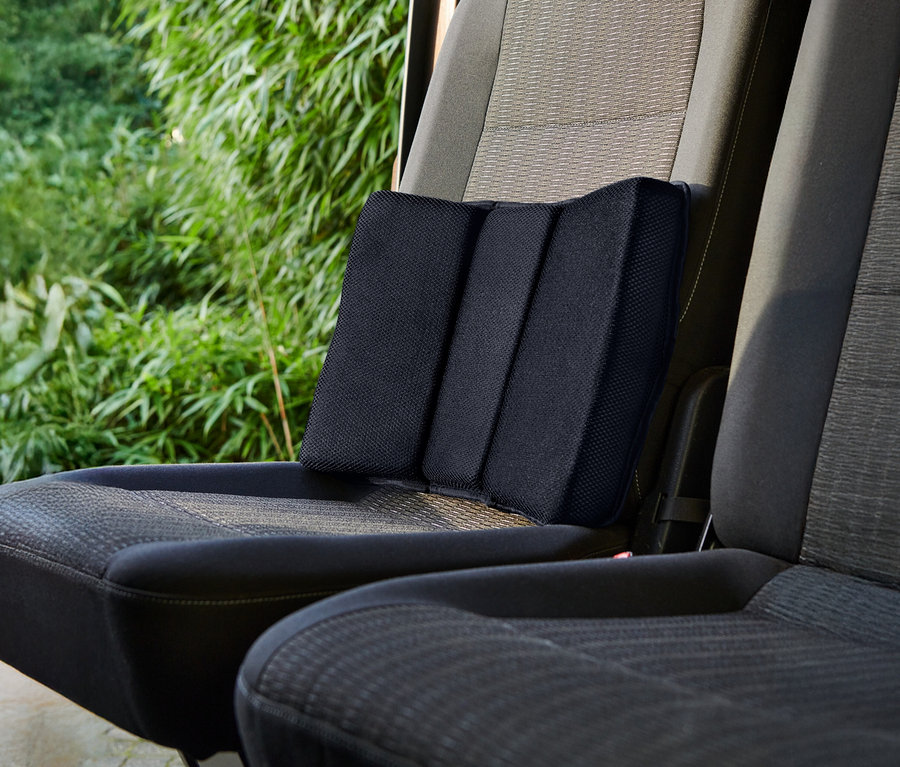 Czarna poduszka lędźwiowa umieszczona na siedzeniu samochodowym.