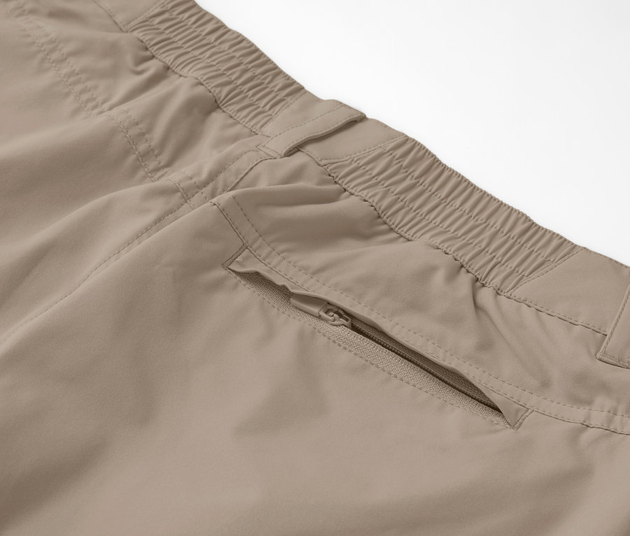 Zbliżenie na beżowe spodnie funkcyjne 2 w 1 z kieszenią na zamek.