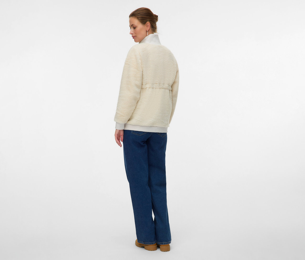 Kobieta od tyłu w pluszowej bluzie 3 w 1 MAMALICIOUS „MLCARLY”, dżinsach i butach.