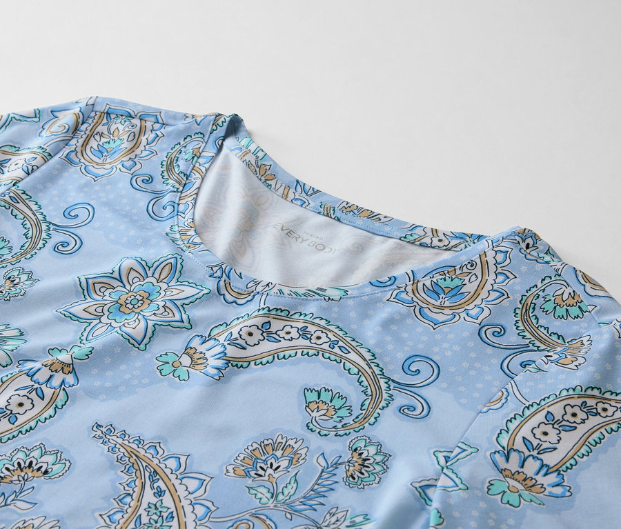 Zbliżenie jasnoniebieskiej koszulki z bladoniebieskim wzorem paisley.