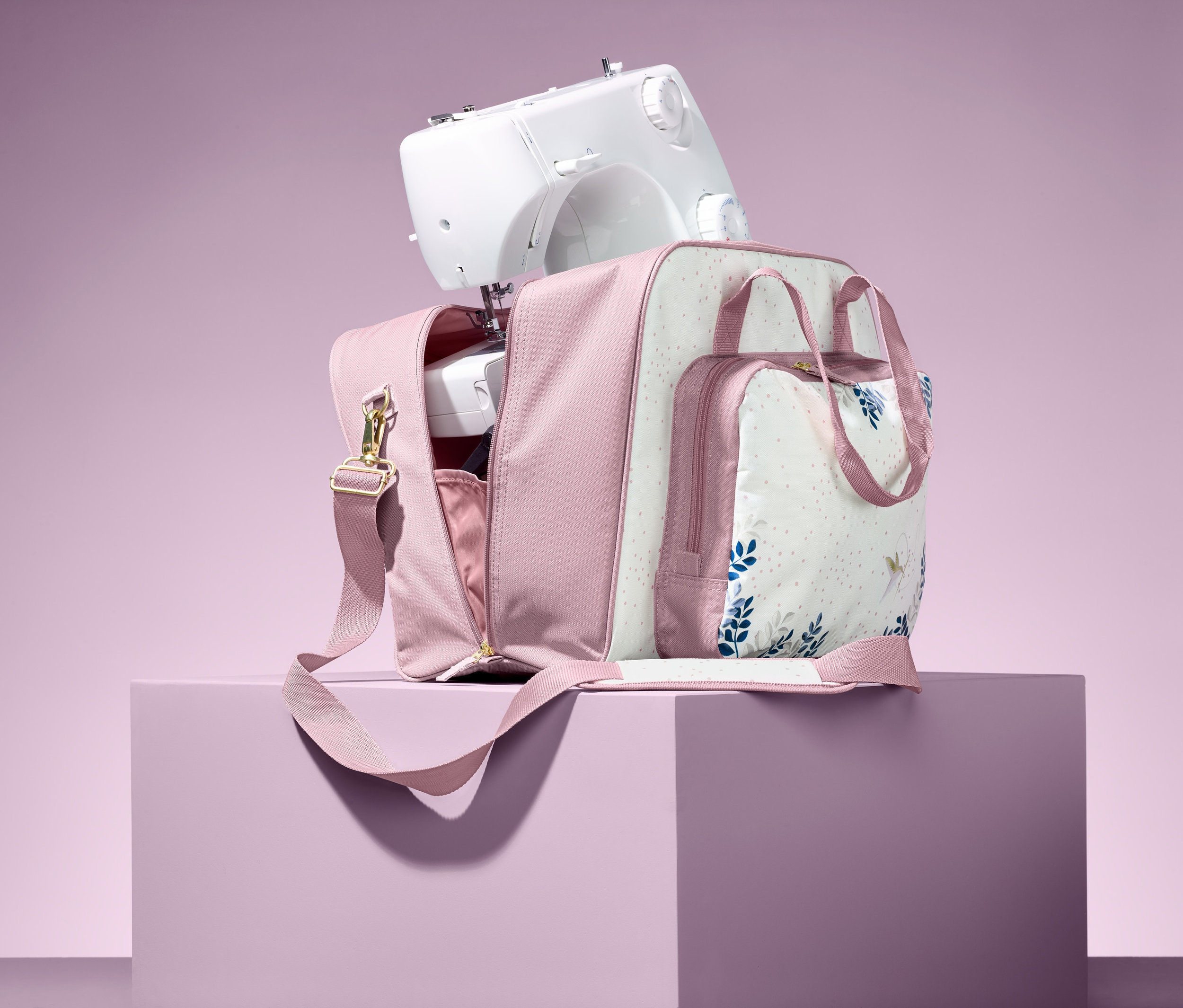 Maszyna do szycia stoi na otwartej torbie na maszynę do szycia.