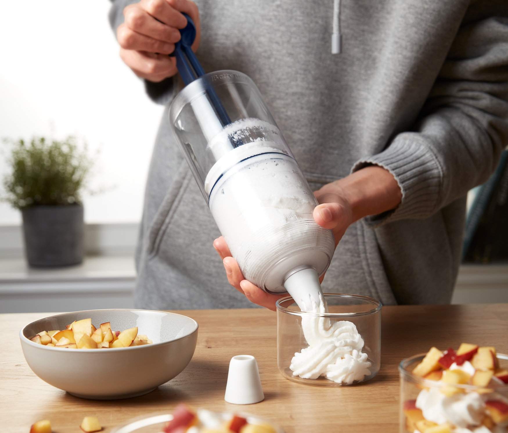 Osoba napełnia deser za pomocą miksera ręcznego do deserów 2 w 1.