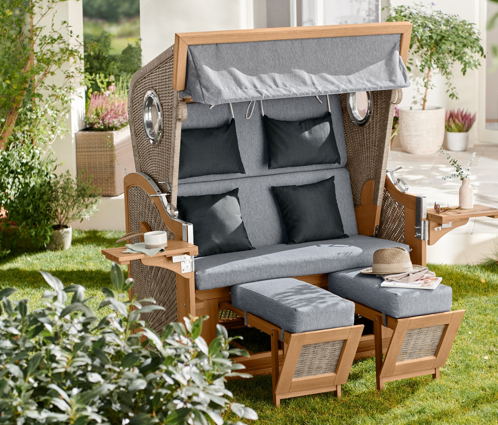 Kosz plażowy premium XXL z 2 stolikami stoi na trawniku.