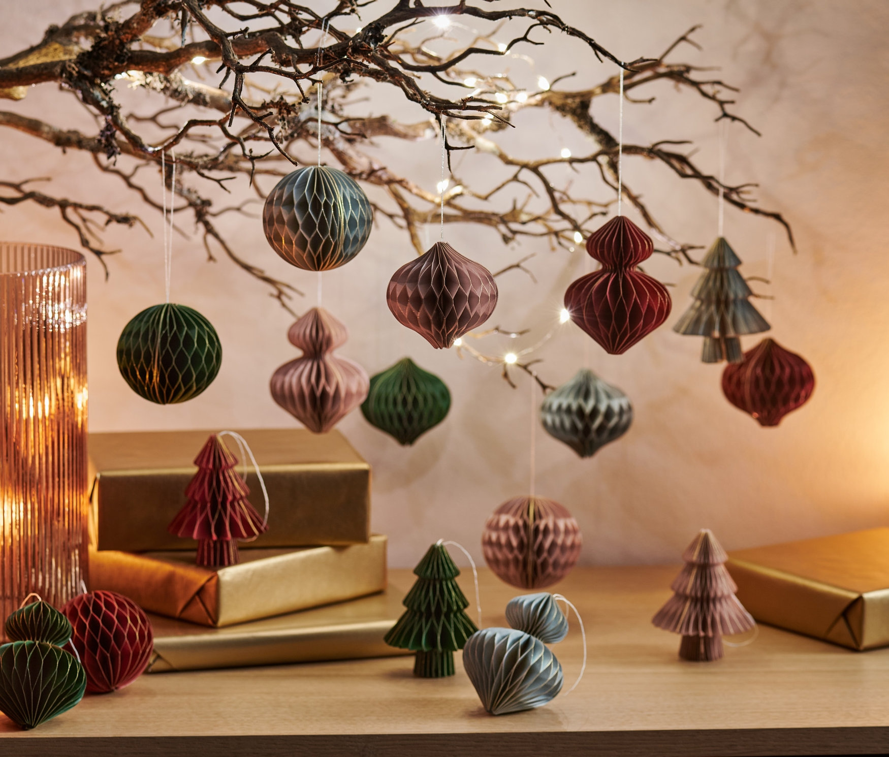 Ozdoby choinkowe, zestaw 16 sztuk, wiszą na gałęzi i leżą na złotych paczkach.