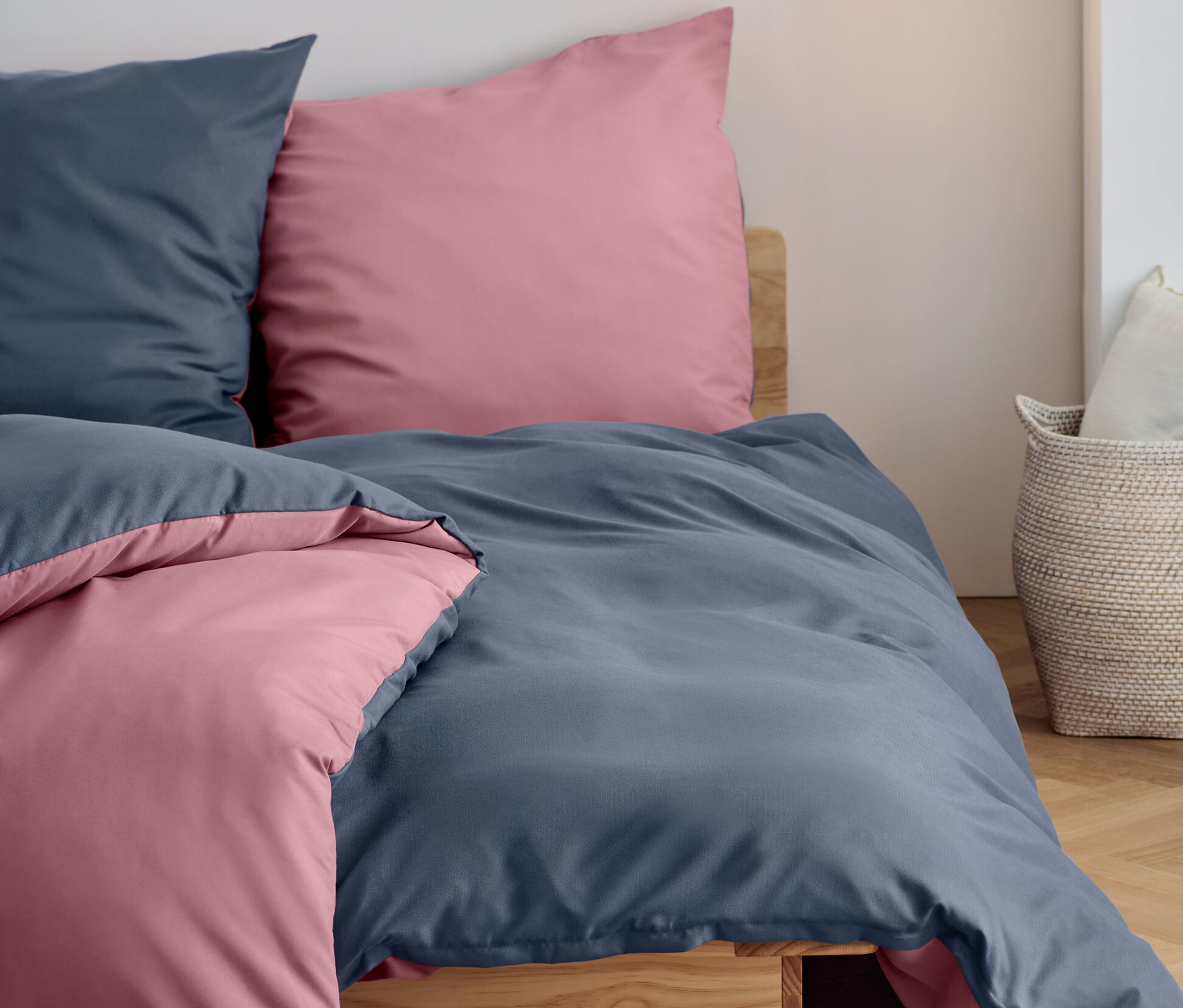 Dwie niebieskie i dwie różowe poduszki i kołdry z pościeli z mikrowłókna i flaneli w rozmiarach standardowych i niestandardowych leżą na łóżku.