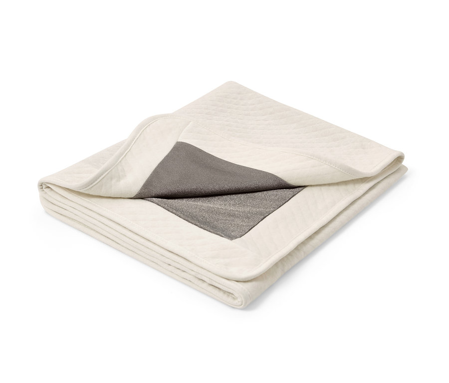 Złożony koc chroniący przed promieniowaniem ze srebrną podszewką.