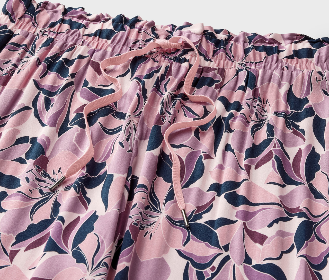 Zbliżenie na spodnie rekreacyjne w kwiatowy wzór ze sznurkiem.