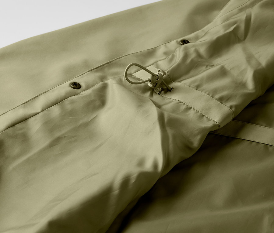 Zbliżenie na khaki płaszcz przeciwdeszczowy z guzikami i sznurkiem.