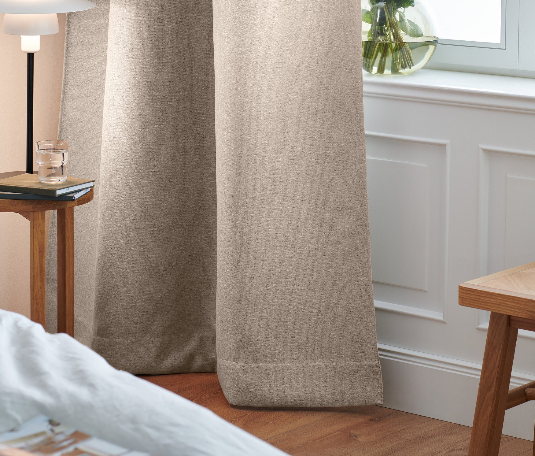Dwie zasłony zaciemniające w sypialni przy oknie.