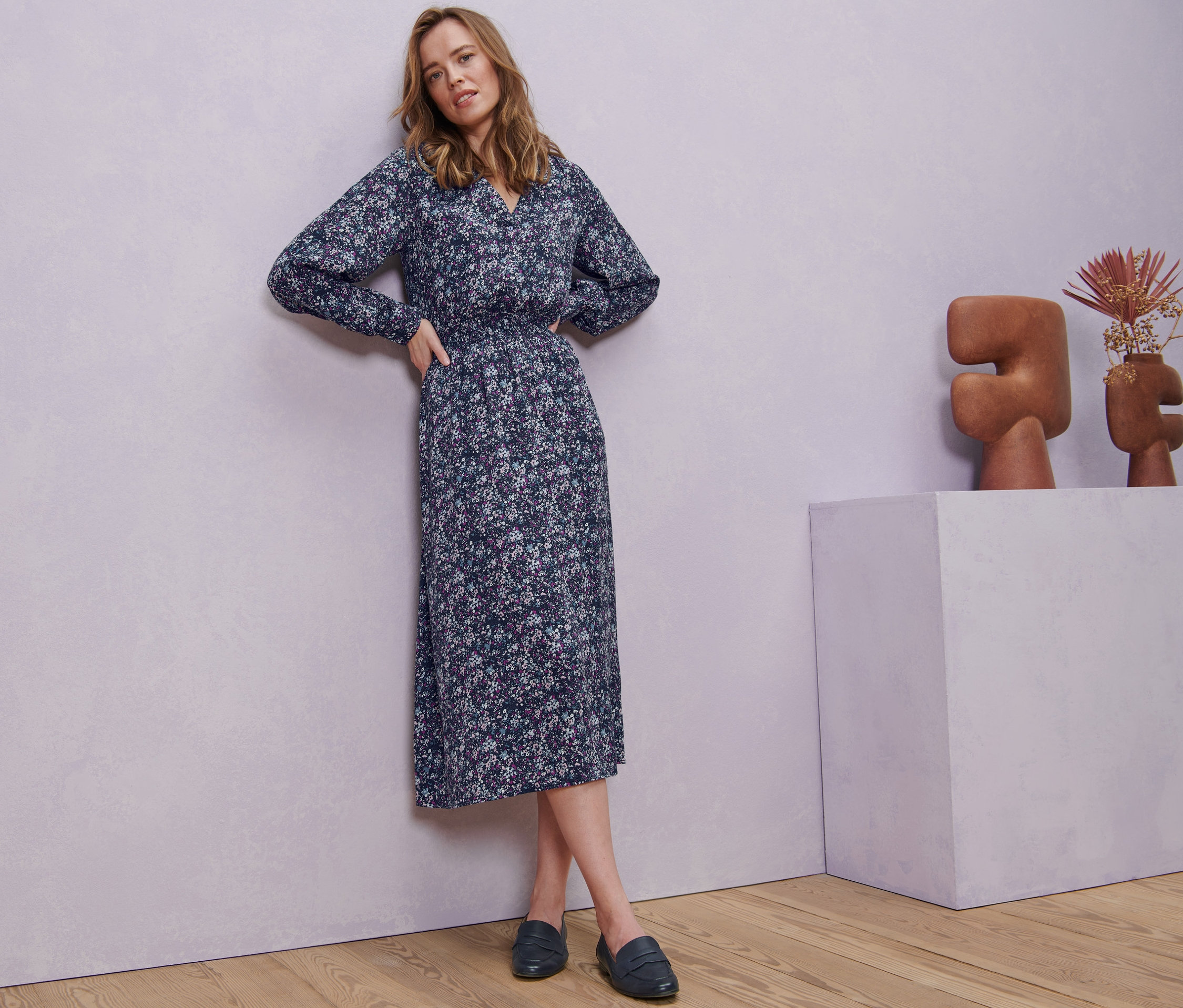 Kobieta pozuje w sukience midi w kwiaty.