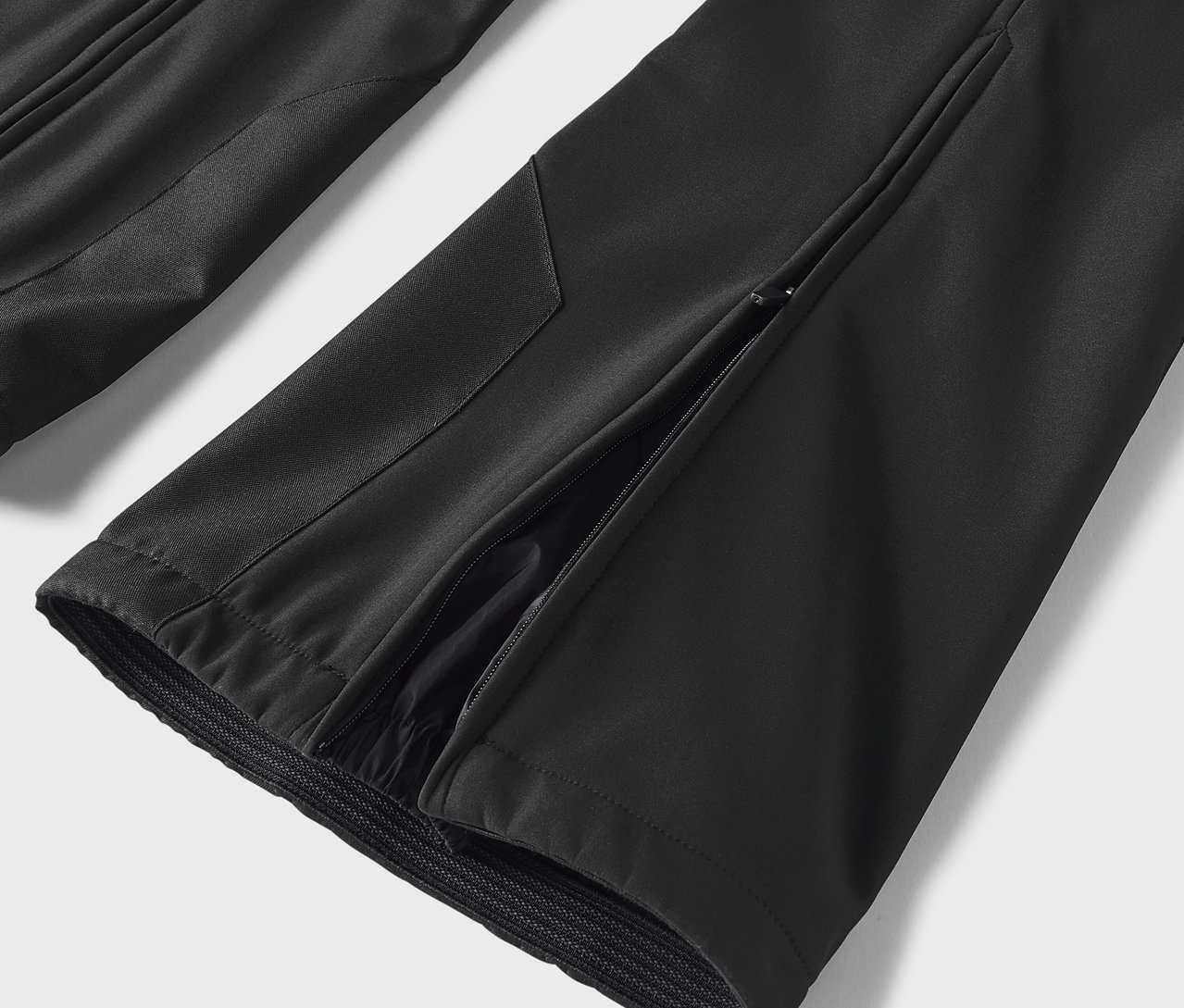 Szczegół czarnych spodni z rozcięciem po stronie.