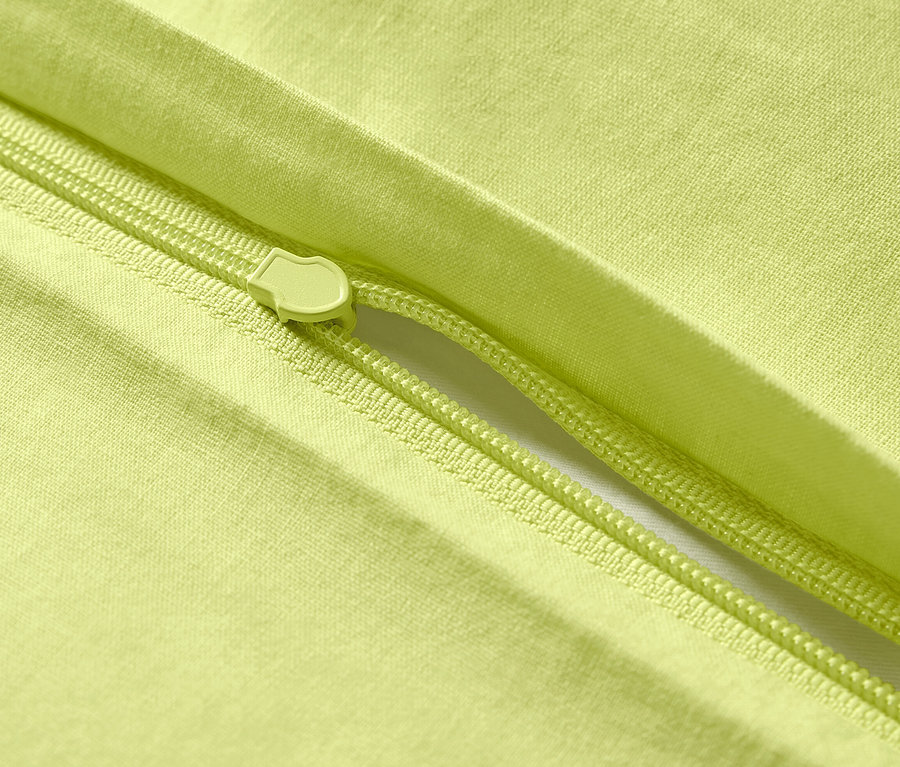 Zbliżenie na żółtą pościel z bawełny renforcé z zamkiem błyskawicznym.