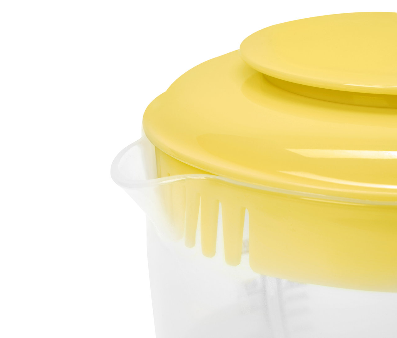 Żółta pokrywka na przezroczystym naczyniu z miarką.