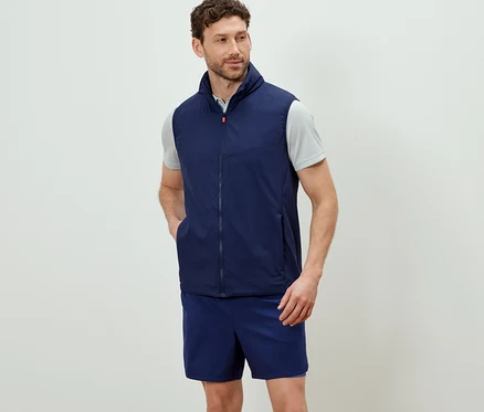 Mężczyzna ma na sobie granatową kamizelkę funkcyjną „packable” i szorty.