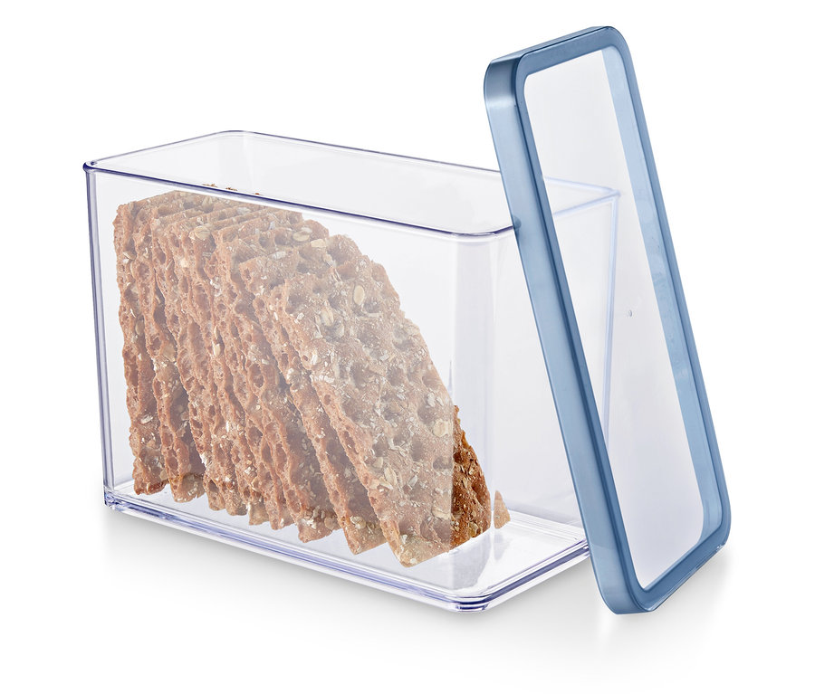 Przezroczysty pojemnik z niebieską krawędzią wypełniony krakersami pełnoziarnistymi.