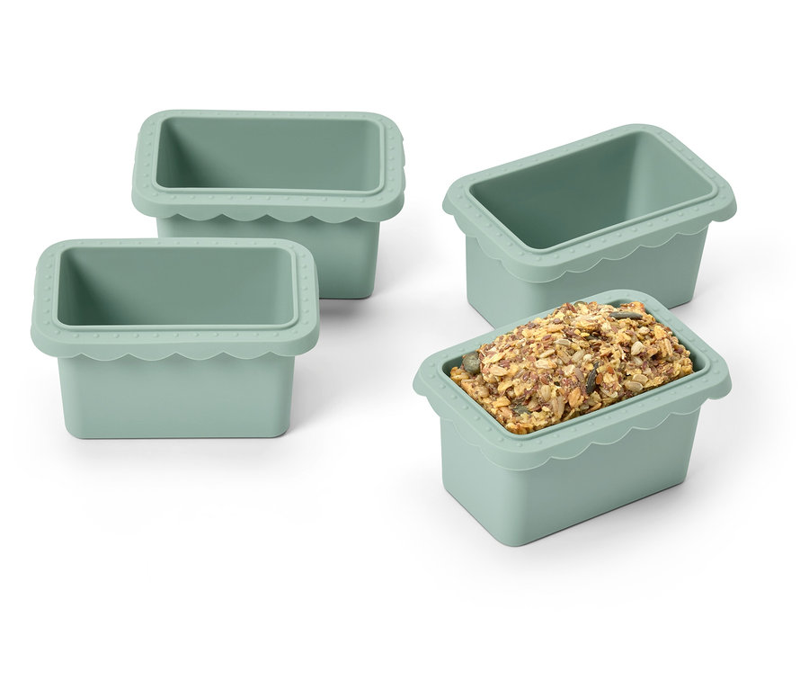 Cztery zielone silikonowe foremki do lodu, jedna wypełniona kostkami lodu.