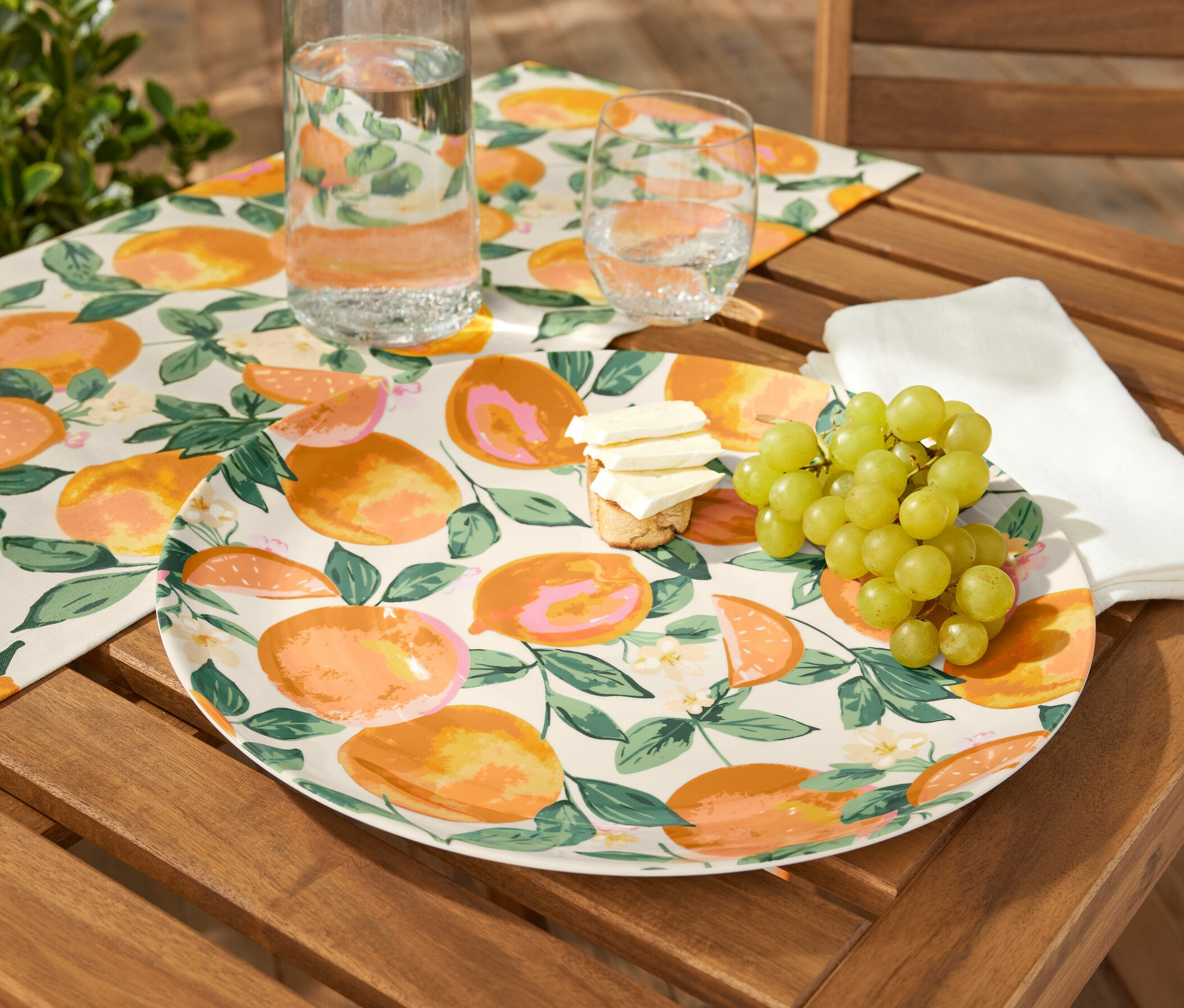 Talerz do serwowania z owocami, serem i winogronami na drewnianym stole.