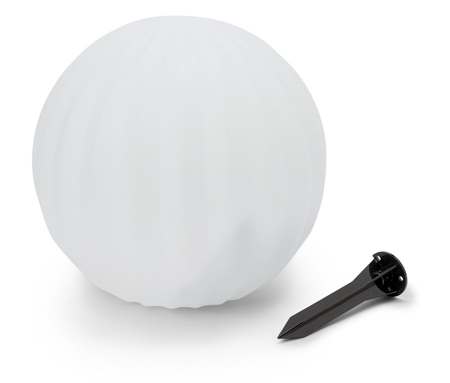 Biała kula leży obok czarnego kolca do ziemi.
