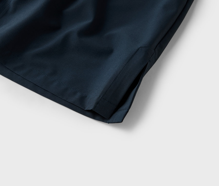 Zbliżenie kieszeni granatowych szortów na białym tle.