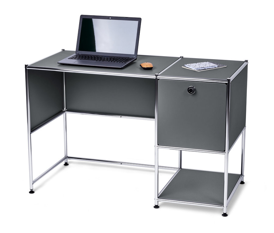 Na szarym metalowym biurku »CN3« z klapą leży laptop i notatnik.