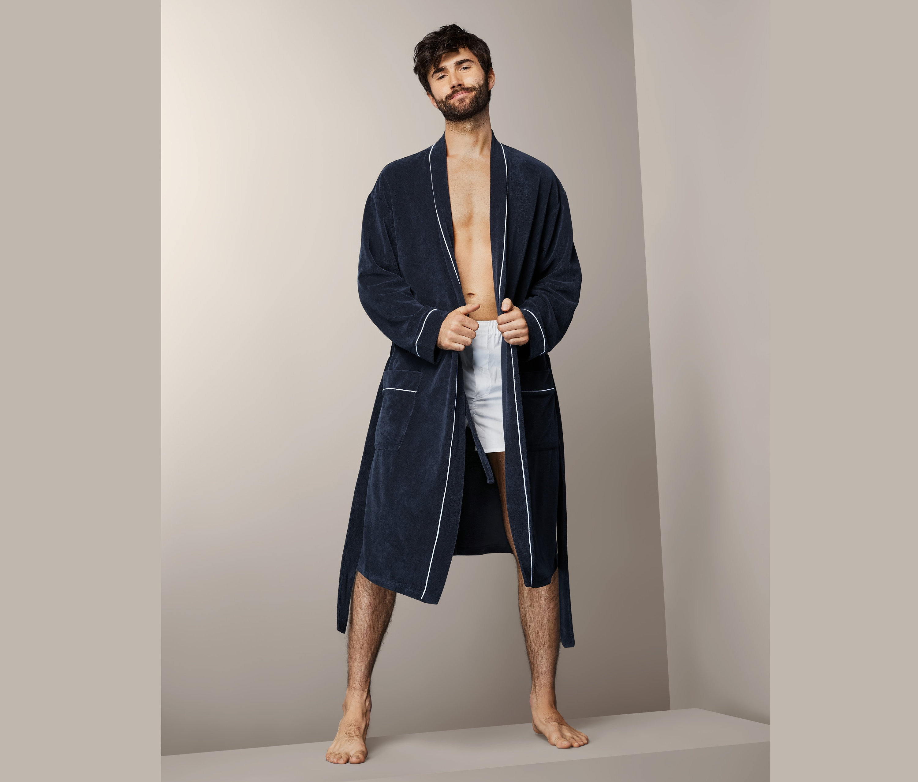 Mężczyzna pozuje w męskim szlafroku.