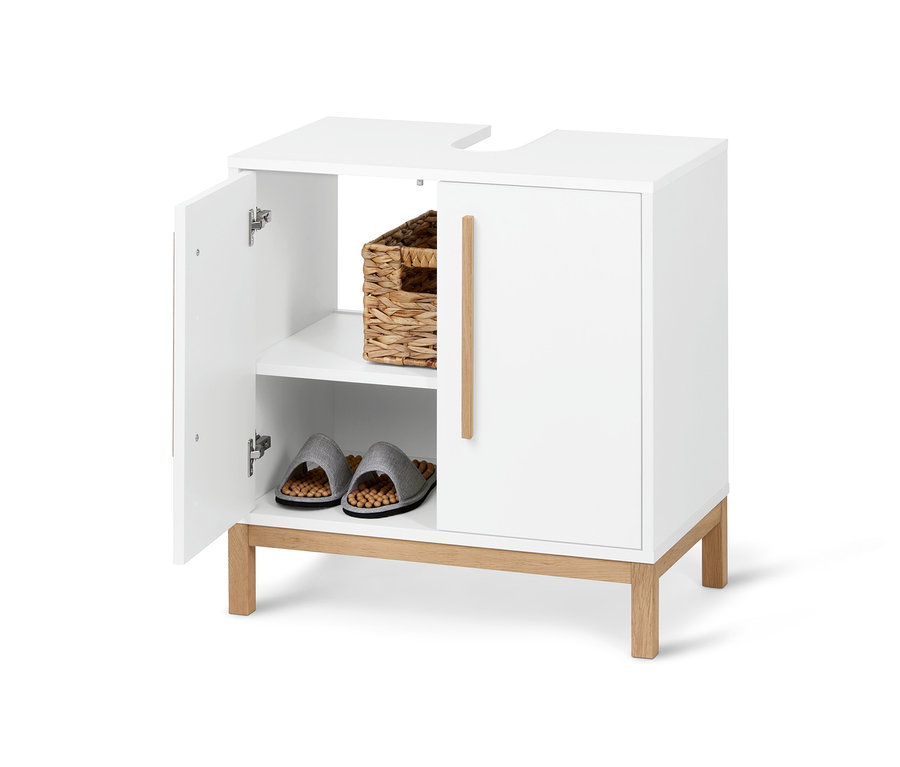Otwarta, biała szafka pod umywalkę Eklund z koszem i kapciami w środku.