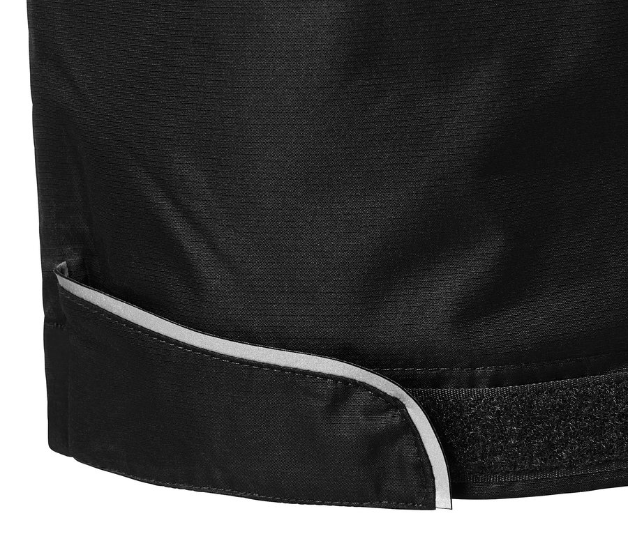 Szczegół czarnych spodni przeciwdeszczowych z odblaskowym brzegiem i zapięciem na rzep.