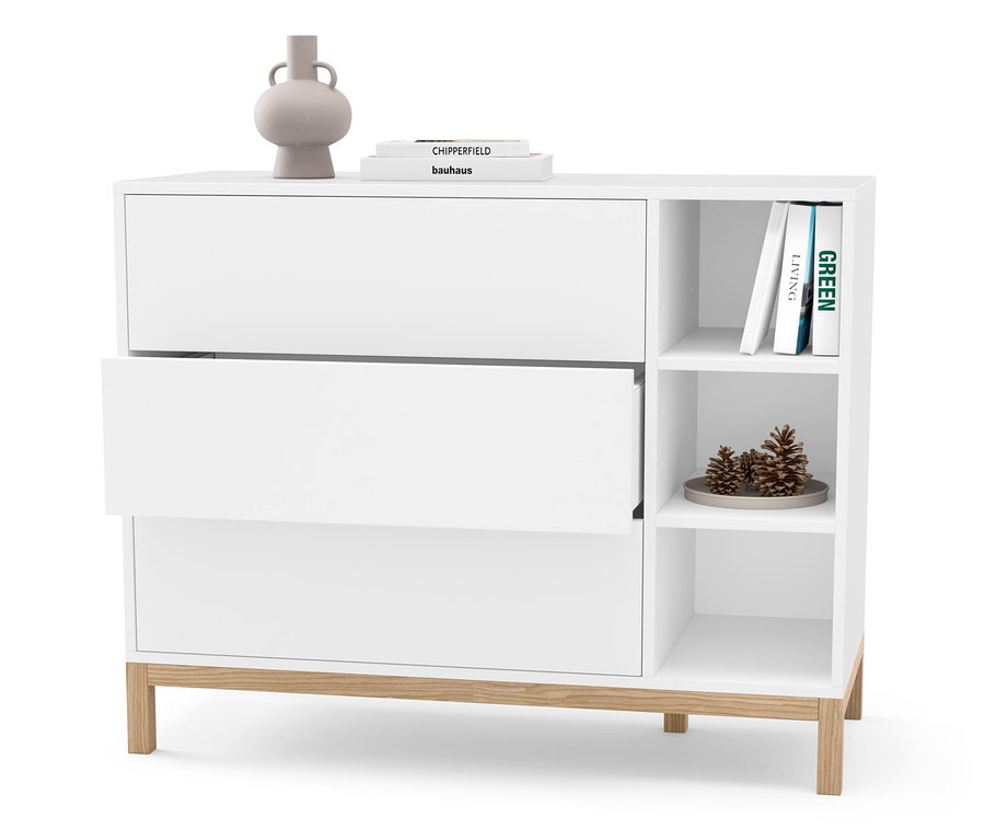 Biała komoda z trzema szufladami, z których jedna jest otwarta. Na komodzie leżą wazon i książki.