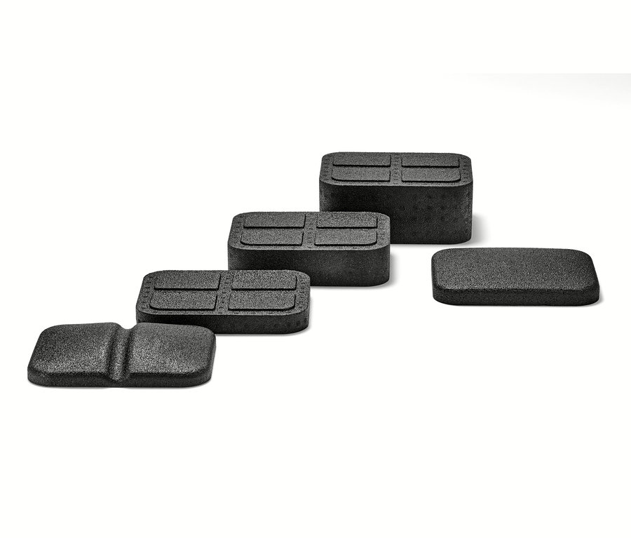 Cztery czarne przyrządy do rozluźniania mięśni pleców na białym tle.