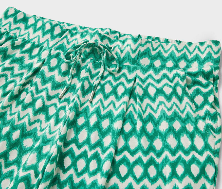 Zbliżenie na wzorzyste spodnie dżersejowe o długości 3/4.