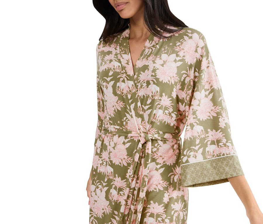 Kobieta ma na sobie kwiecisty szlafrok w kolorze zielonym i różowym.