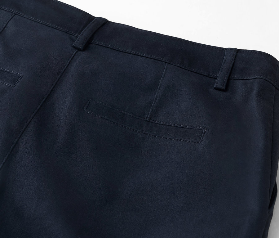 Szczegółowy widok z tyłu granatowych spodni z kieszenią na pośladku.