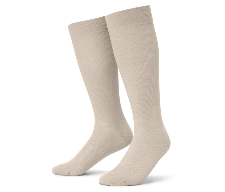 Zbliżenie dwóch par beżowych podkolanówek na białym tle.