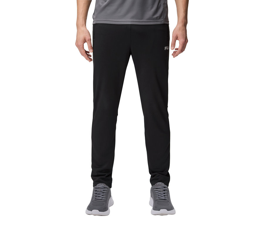 Mężczyzna nosi czarne spodnie dresowe i szare trampki.