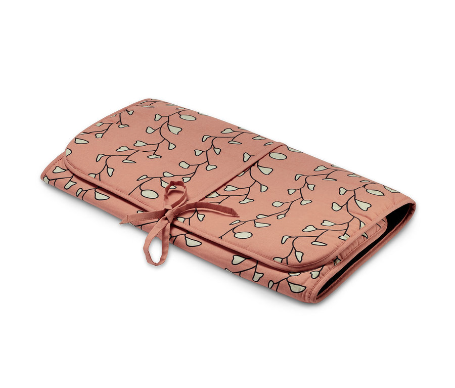 Składana mata do prasowania w kwiatowy wzór, związana wstążką.