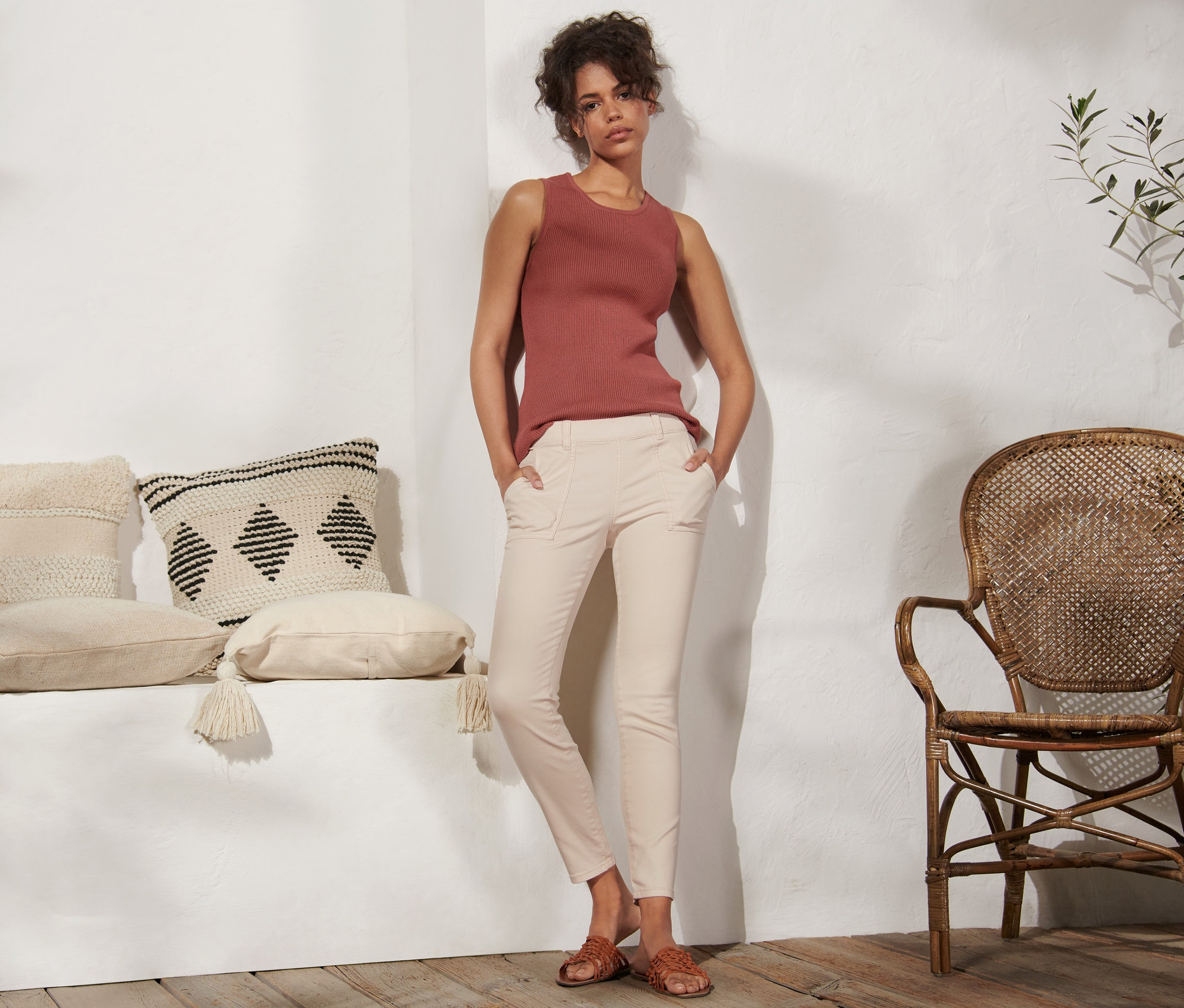 Kobieta stoi z rękami w kieszeniach tregginsów.