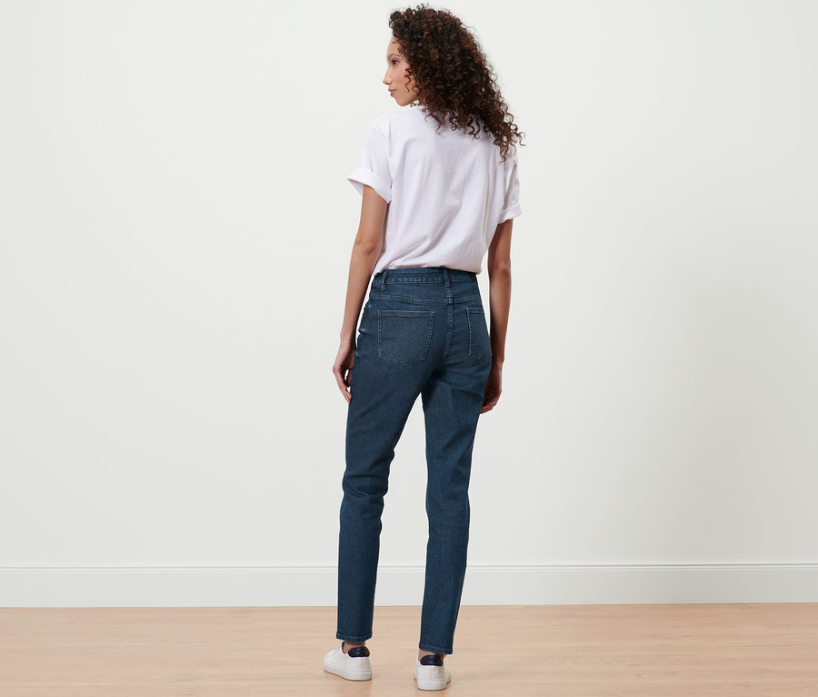 Kobieta z tyłu w ciemnoniebieskich jeansach slim »Fit Emma« i białym t-shircie.