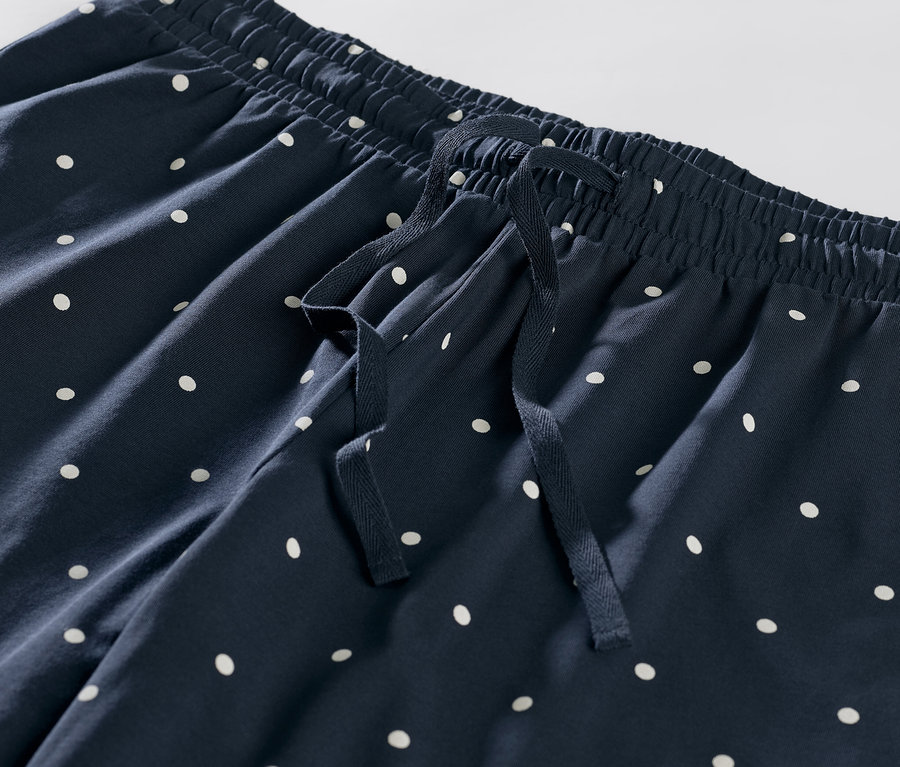 Zbliżenie na spodnie od piżamy w kropki.